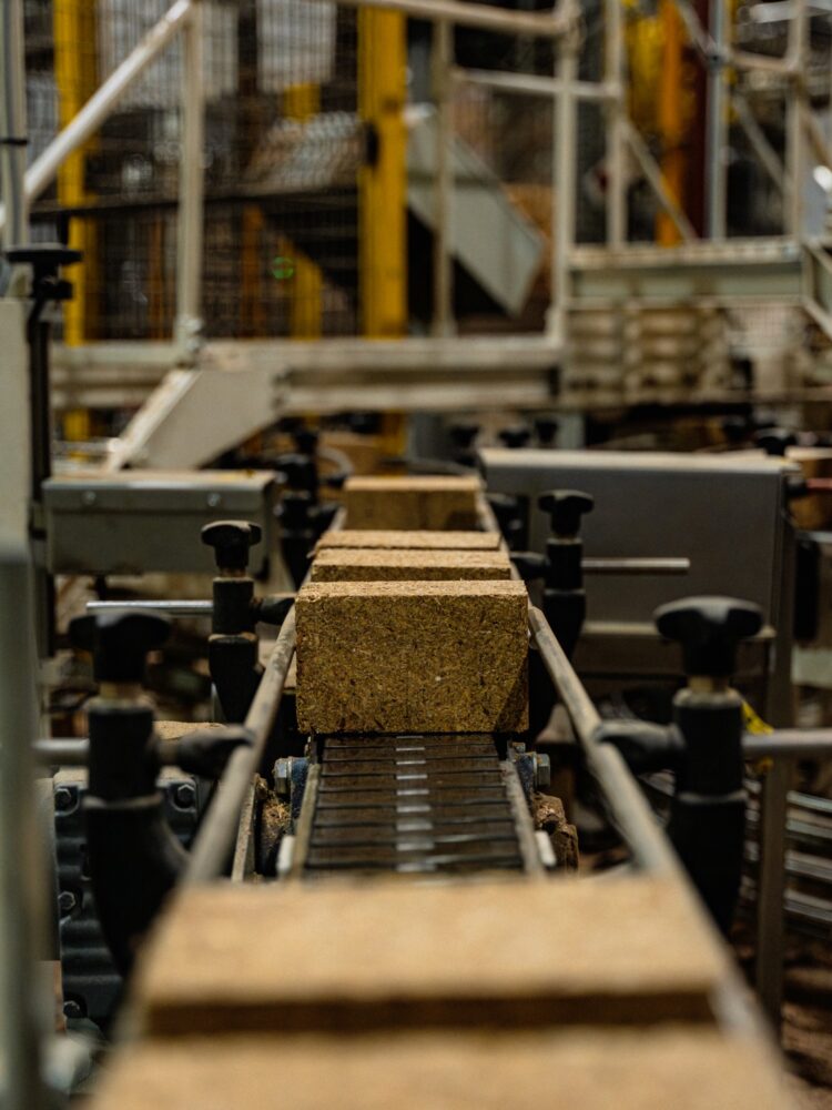 A single composite pallet block travelling along a roller conveyor inside the Eirebloc plant.