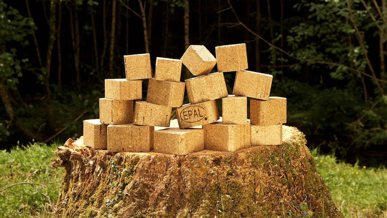 Composite pallet blocks stacked on a tree stump in woodland, one stamped with the EPAL mark.